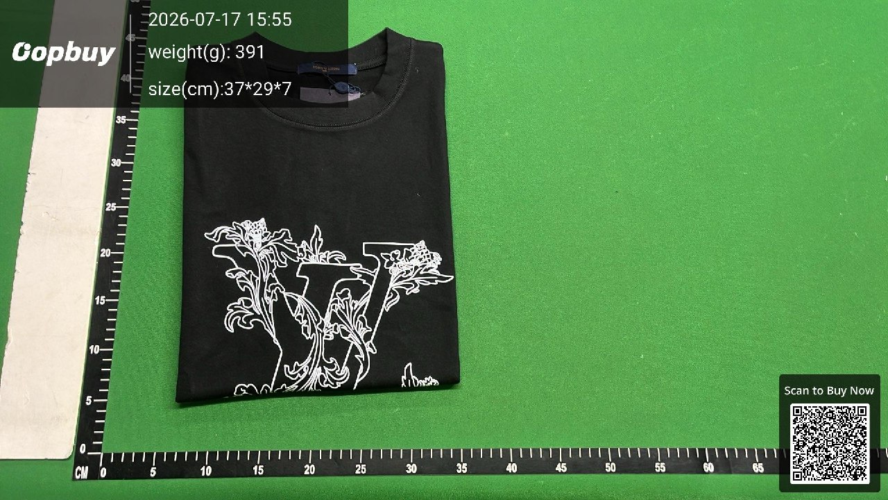 T-shirt nera piegata sul piano verde con righelli